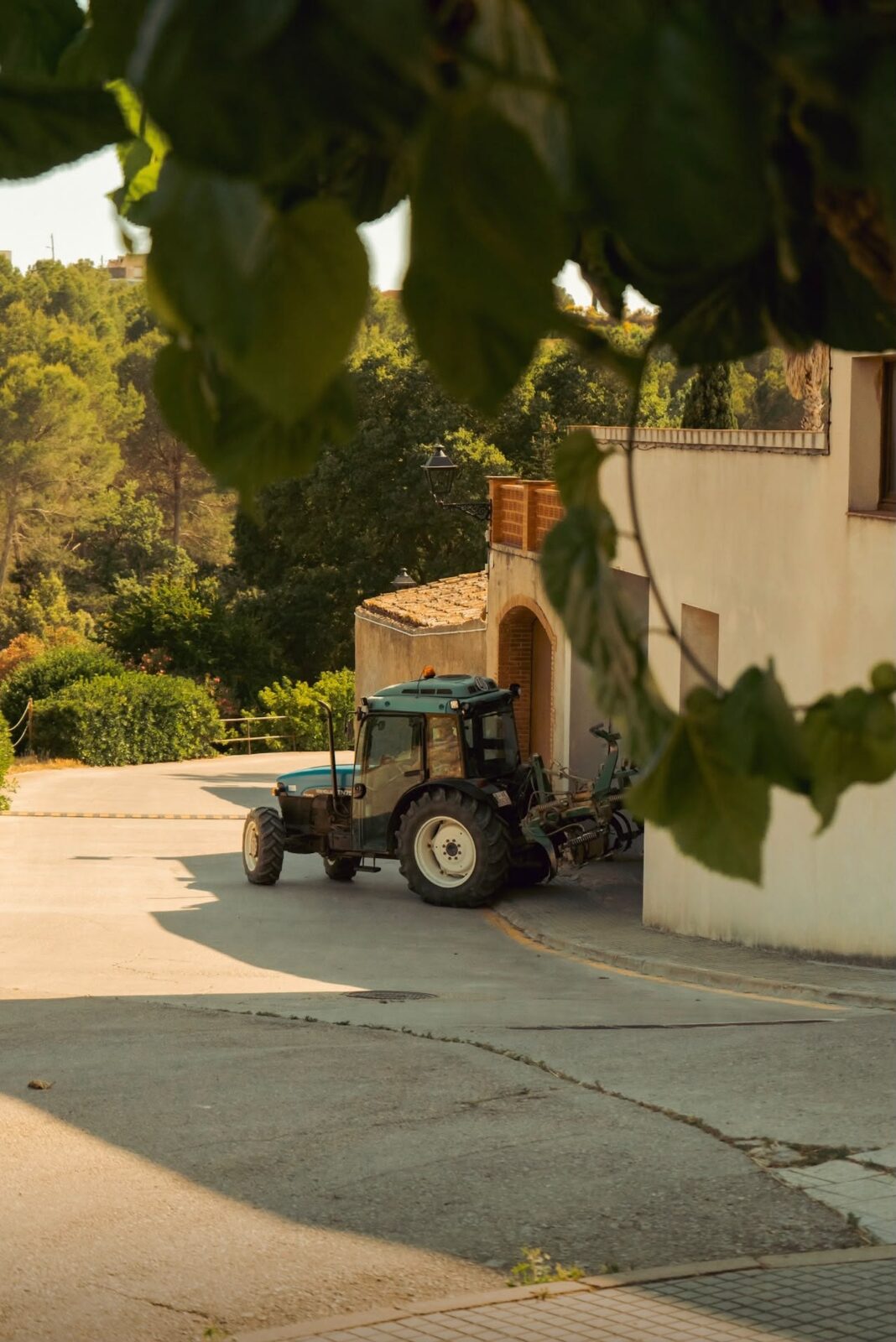 Calle del pueblo con tractor entre viñedos