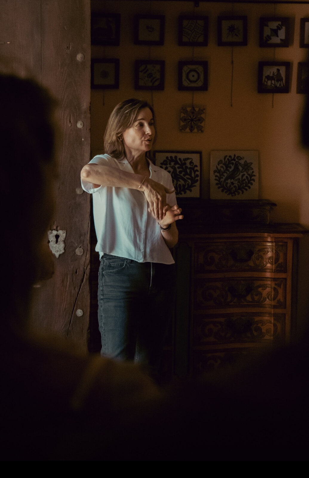 Profesora dando clase en una sala con azulejos